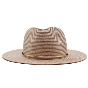 Detail eines beigen Strohhutes mit edlem Gold-Akzent und breiter Krempe im Fedora-Stil