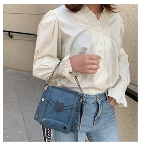 Blaue Umhängetasche mit Herzschnalle und Ketten-Griff in modischer Streetstyle-Ansicht