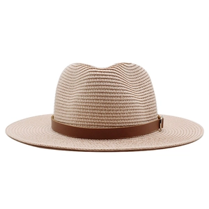 Detail of woven straw texture and brown leather strap with silver metal buckle on hat