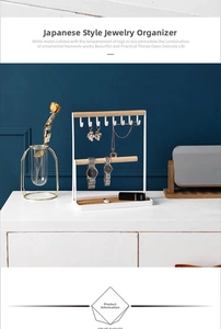 Detail of white metal jewelry stand with wooden bars and hooks for necklaces and rings