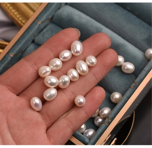 Macro shot of high-luster white freshwater pearls held in hand for DIY jewelry making
