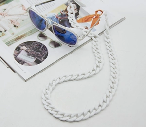 Close-up of white acrylic glasses chain on an aviation magazine with pilot sunglasses