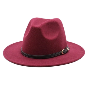 Close-up of burgundy fedora hat with black leather band and gold metal buckle detail