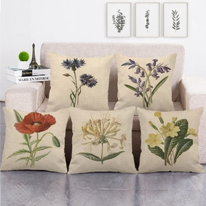 Detail showing vintage floral botanical patterns on five linen cushion covers on a sofa