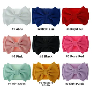 Detail showing nine colors of waffle fabric baby headbands with large bows on white background