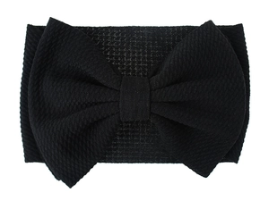 Close-up of black waffle fabric baby headband featuring a large oversized textured bow