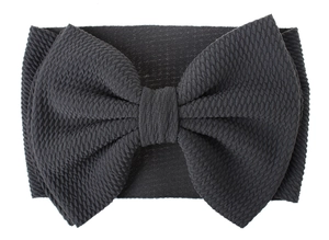 Detail of dark grey waffle knit baby headband with oversized textured bow design