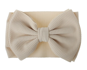 Detailed view of cream elastic knit texture and oversized bow on the children's headband