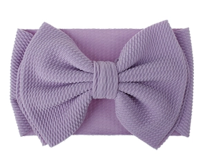 Detail of purple oversized bow headband for babies in textured waffle knit fabric
