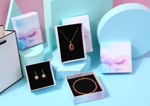 Detail of jewelry gift box set with purple mountain illustration and matching paper bag