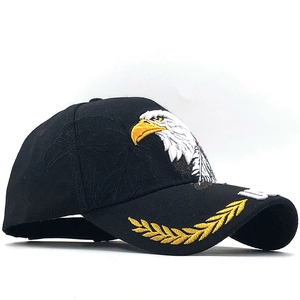 Detail of eagle and golden laurel leaf embroidery on a black cotton baseball cap