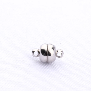 Close-up of a silver magnetic clasp for DIY jewelry making on white textured fabric