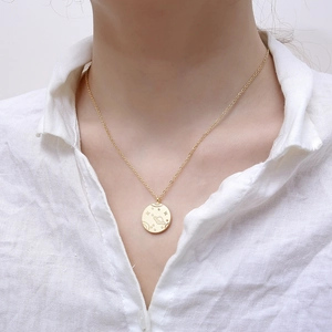 Collier médaille planète dorée avec pendentif Saturne porté par un mannequin