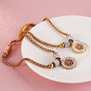Elegant Tree of Life bracelets in gold and rose gold with pavé crystals on a white plate