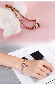 Detail of rose gold tree of life bracelet with rhinestones and box chain shown on wrist