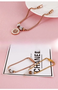 Detail of tree of life charm bracelets in rose gold and gold with sparkling zircons