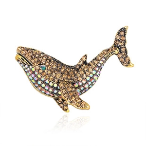 Macro shot of whale brooch featuring champagne crystals and golden metal finish