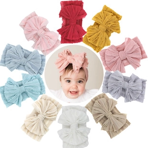 Selection of ten colorful baby bow headbands arranged around a center model display