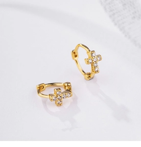 Macro shot of gold S925 sterling silver hoop earrings with sparkling cross pendants