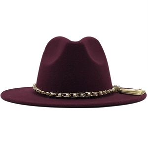 Close-up of wine red fedora hat featuring pearl gold chain and tassel detail