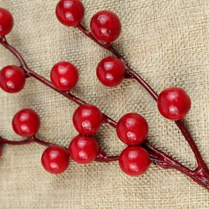 Macro detail of glossy red artificial berries on branches for Christmas decor