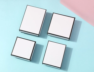 Minimalist white jewelry boxes with black trim in square and rectangular shapes