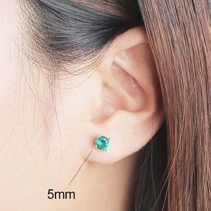 Vue latérale macro d'une boucle d'oreille émeraude 5mm sertie de quatre griffes en argent