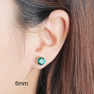 Détail des boucles d'oreilles émeraude 6mm en argent S925 portées par un mannequin sur l'image