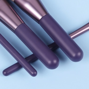 Close-up of purple makeup brush set showing various bristles and soft textures