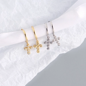 Detail view of gold and silver S925 sterling silver mini cross hoop earrings with zircon