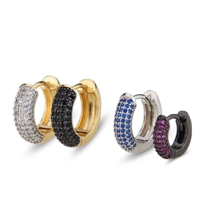 Detailed macro view of gold, silver, and black huggie earrings with colorful zircon stones