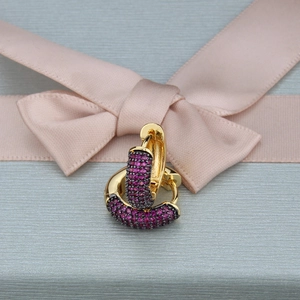 Close-up of gold hoop earrings with purple zircon on a blue gift background