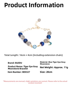 Detail of blue tiger eye and grey moonstone beaded bracelet with evil eye charm and pendants