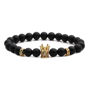 Matte black beaded bracelet featuring a gold crown charm with colorful micro-inlaid stones
