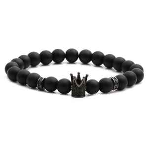 Matte black stone beaded bracelet featuring a black crown charm on white background