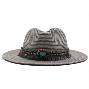 Detail of grey bohemian straw hat with turquoise beads and tassel decoration