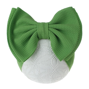 Detail of green oversized bow headband for babies with waffle knit fabric texture