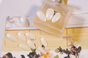 Macro detail of pearlescent white almond false nails with Aurora butterfly shimmer finish