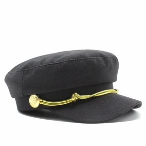 Detail of black baker boy cap with gold braided rope and embossed metallic side buttons