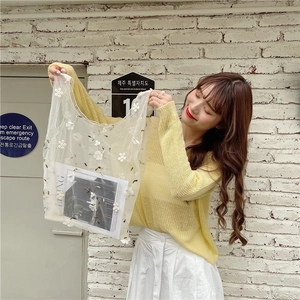 Detail of white mesh tote bag featuring delicate 3D floral embroidery and mesh texture