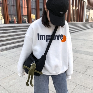 Close-up of a white cotton sweatshirt with Improve print and a green frog bag charm