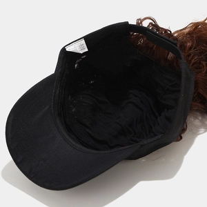 Détail de la couture intérieure et de l'extension de cheveux ondulés sur la casquette