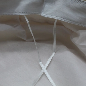 Detail view of the inner lining and adjustable white ties on this stylish beret hat
