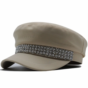 British style beige baker boy hat with pearl and rhinestone accents on white background