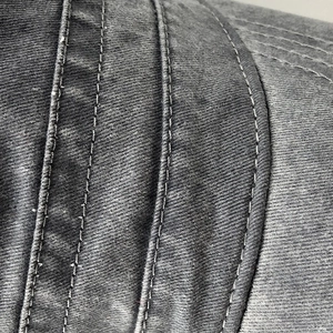 Detail view of four parallel reinforced topstitching lines on washed cotton military cap