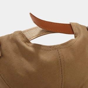 Close-up of adjustable velcro and leather strap on khaki canvas sailor docker cap