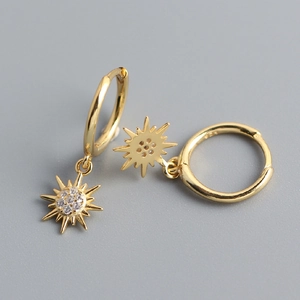 Detail of S925 sterling silver gold hoop earrings with sparkling sunburst charms