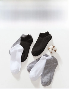 Detailed shot of breathable low-cut socks in black, white, and grey with cotton flower