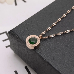 Collier en titane or rose avec pierre verte et chiffres romains sur boîte noire
