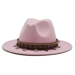 Detail of light pink wool fedora hat featuring ethnic ribbon and vintage coin charms